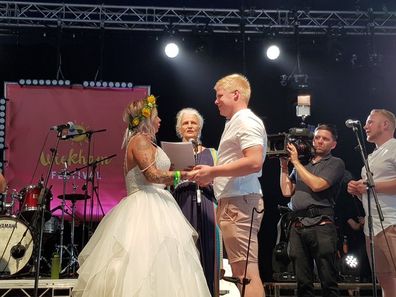 The couple saying their vows on the festival stage