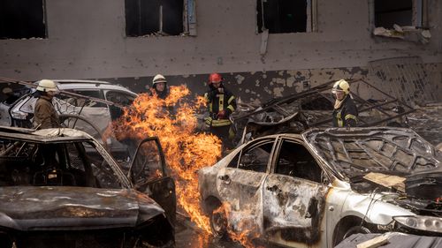 Firefighters work to extinguish a fire at shopping centre in Kharkiv after a Russian missile attack. 