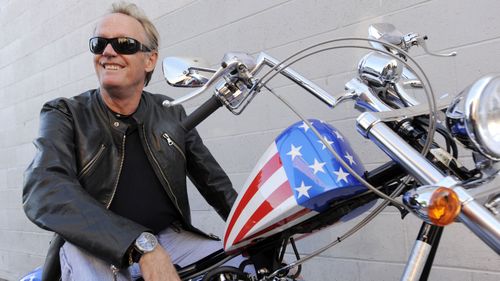 File photo from 2009, Peter Fonda, poses atop a Harley-Davidson motorcycle in Glendale, California.