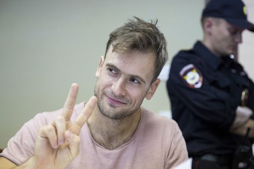 Pyotr Verzilov, a member of the feminist protest group Pussy Riot, gestures during hearings in a court in Moscow, Russia, Monday, July 23, 2018. Four members of the feminist protest group Pussy Riot, who had run onto the pitch dressed in police uniforms during the World Cup final, were sentenced in Moscow City Court on Monday. (AP Photo/Pavel Golovkin)