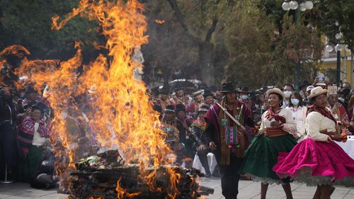 Aymara Indigenous dance around burnt offerings in honor of Pachamama or Mother Earth, in the run up to the 5,530th Aymara New Year, in La Paz, Bolivia.