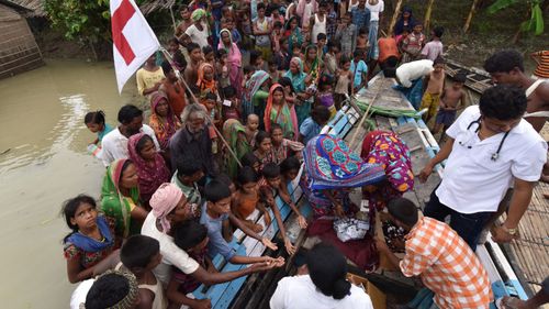 Officials distribute medicine to villagers in the flood affected Sagolikota area in India's north east. (AFP)