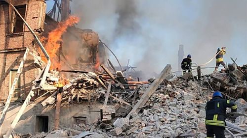 Emergency personel clear away debris after a bomb destroyed a school in the village of Bilohorivka, Ukraine on Saturday June 7.