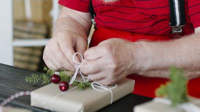 Santa wrapping Christmas gifts.