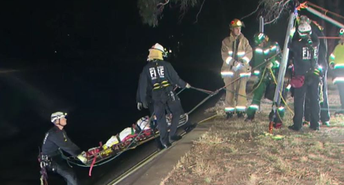 Emergency rescue crews had to rappel down the steep edges of the drain to stabilise the man, who had suffered spinal injuries. Picture: 9NEWS.