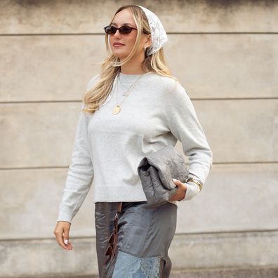 COPENHAGEN, DENMARK - AUGUST 06: A guest wears bleu jeans, sheer dress, light grey sweater, white head scarf, grey bag and flip flops outside Munthe show during Copenhagen Fashion Week day three on August 06, 2025 in Copenhagen, Denmark. (Photo by Raimonda Kulikauskiene/Getty Images)