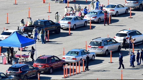 People arrive for their COVID-19 vaccine at the Auto Club Speedway in Fontana, California on February 2, 2021 - The first Covid-19 vaccine 'super site' in San Bernadino County - California's largest county - opened on Tuesday.