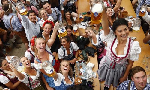 Young women lift glasses of beer during the opening of the 185th 'Oktoberfest' beer festival in Munich, Germany.