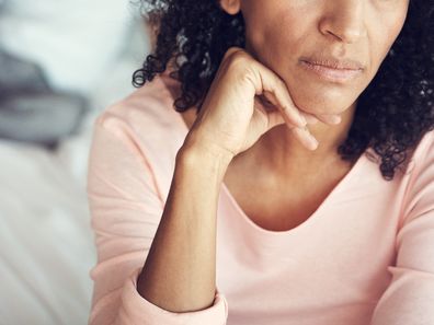 Woman looking upset with her husband in the background