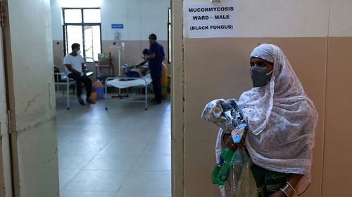 A woman stands outside as a patient infected with black fungus is treated at a government hospital in Hyderabad, India, on May 20.