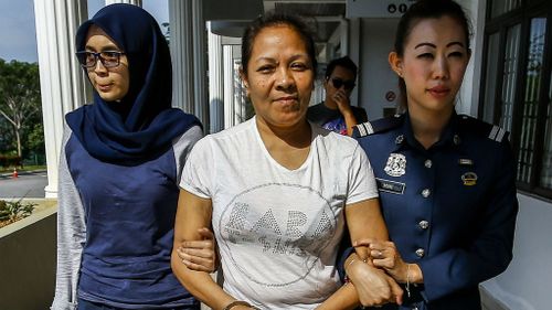 Australian Maria Elvira Pinto Exposto is escorted by Malaysia Customs officer outside the magistrate court in Sepang. (AAP)