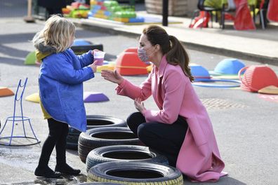 Kate Middleton, Duchess of Cambridge talks with a child in the water area of the playground during a visit with Prince William to School21, a school in east London, Thursday March 11, 2021