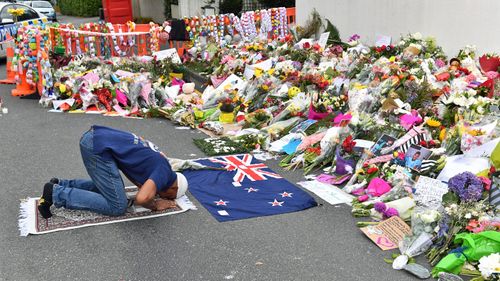 A muslim worshipper prays at a makeshift memorial near the Al Noor Mosque on Deans Rd in Christchurch.