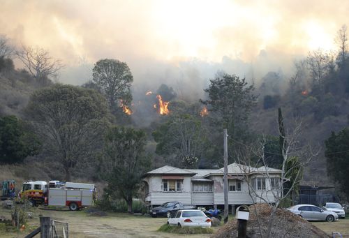 Fire and Emergency crew battle bushfire near a house in the rural town of Canungra in the Scenic Rim region of South East Queensland, Friday, September 6, 2019. (AAP Image/Regi Varghese) NO ARCHIVING