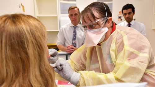 A GP performs a mock coronavirus examination on a patient inside the fever clinic at the Prince Charles Hospital in Brisbane.