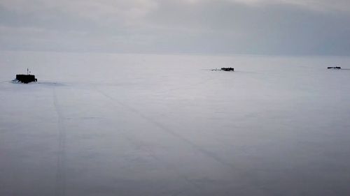 Russian nuclear submarines break through the Arctic ice during military drills at an unspecified location 