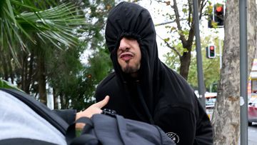 Issa Haddad covered his face with a black hoodie as he left court and yelled at reporters.