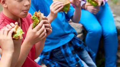 Kids eating good food sandwiches