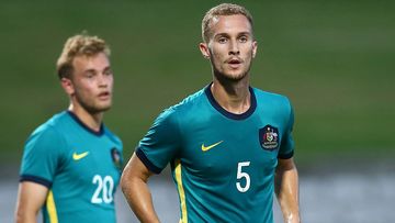 Tass Mourdoukoutas of the Olyroos looks on.