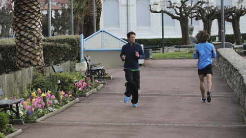 People jog along the beach promenade Tuesday, March 17, 2020 in Saint Jean de Luz, southwestern France. 