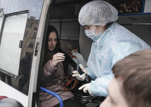 An emergency medic helps Alla Ilyina to fasten a seat belt inside an ambulance after a court session in St Petersburg.