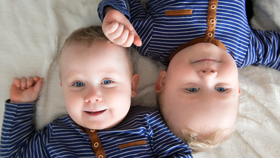 Twin baby boys starting at the camera.