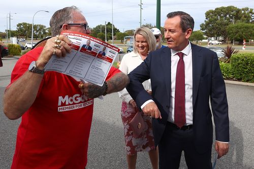 West Australian Premier Mark McGowan and his wife Sarah McGowan bump elbows with a campaigning volunteer.