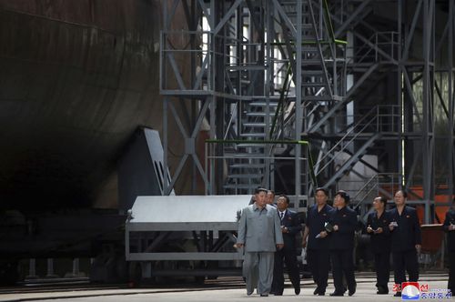 North Korean leader Kim Jong Un, left, inspects a newly built submarine to be deployed soon, at an unknown location in North Korea. 