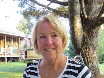 Kim Durkee smiling in front of a tree.