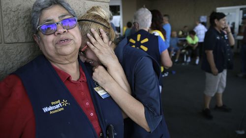 Walmart employees comfort each other after the shooting.