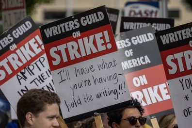 LOS ANGELES, CA - MAY 04: People picket outside of Paramount Pictures studios during the Hollywood writers strike on May 4, 2023 in Los Angeles, California. Scripted TV series, late-night talk shows, film and streaming productions are being interrupted by the Writers Guild of America (WGA) strike. In 2007 and 2008, a WGA strike shut down Hollywood productions for 100 days, costing the local economy between $2 billion and $3 billion. (Photo by David McNew/Getty Images)