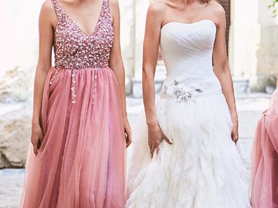 bride standing with bridesmaid wearing a pink dress
