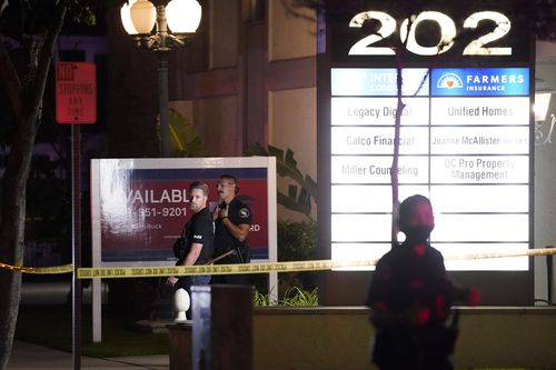 Des policiers se tiennent devant un immeuble commercial où une fusillade a eu lieu à Orange.  Quatre personnes sont mortes, dont un enfant.