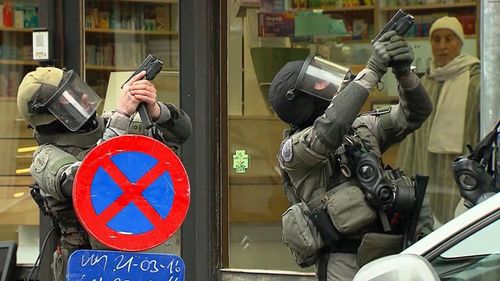 Armed police officers take part in a raid in the Molenbeek neighborhood of Brussels, Belgium. (AAP)