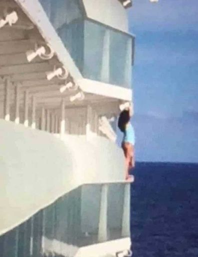 Woman hangs off balcony for photo shoot on cruise ship