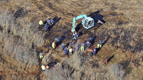 In this December 8, 2011 photo, investigators use a backhoe to dig while searching for Shannan Gilbert's body in different sectors of a marsh area just east of Oak Beach, N.Y. 