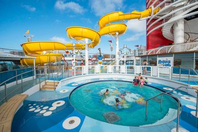 An outdoor circular pool and yellow water slide