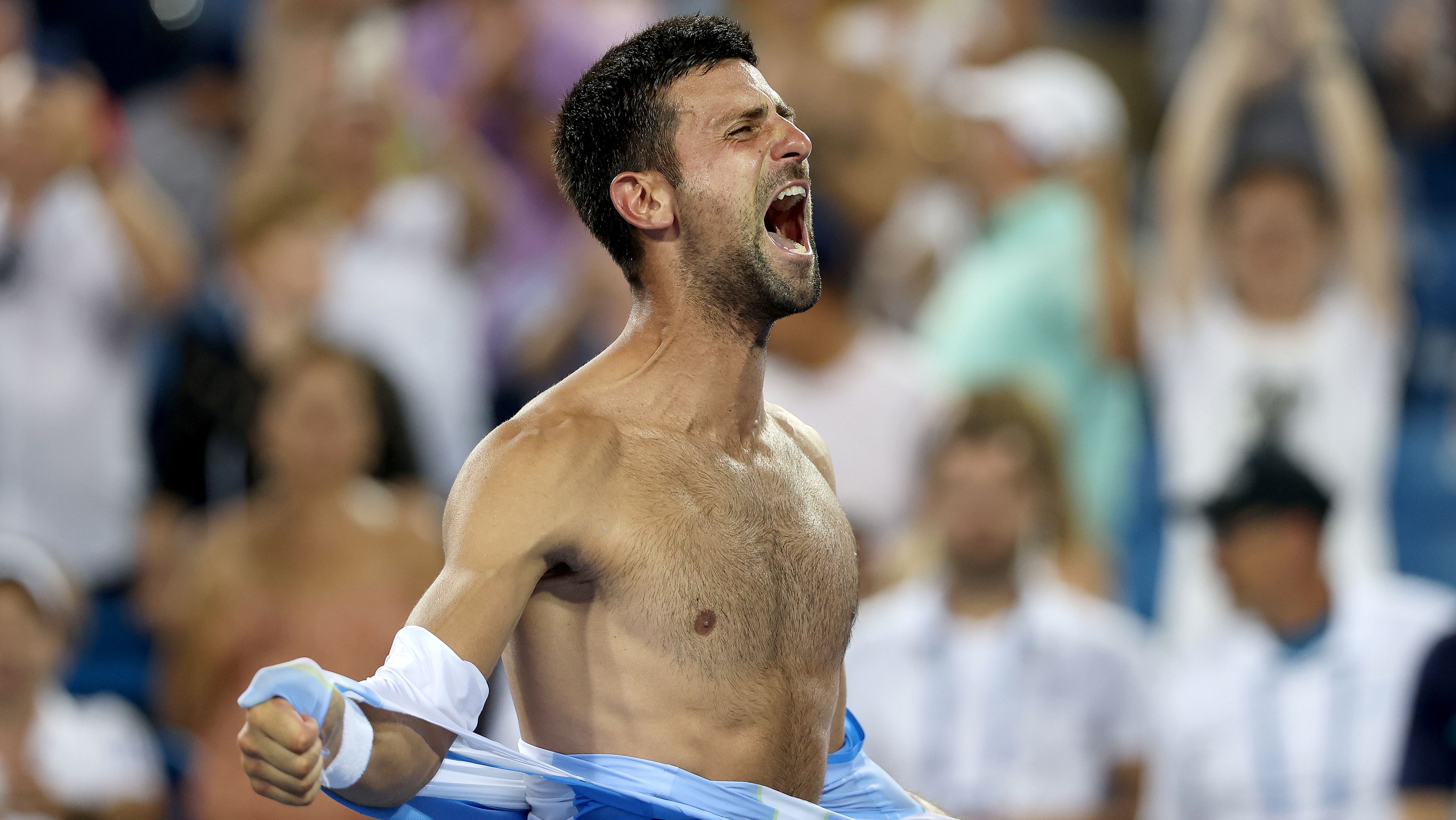 Novak Djokovic of Serbia tears his shirt off after defeating Carlos Alcaraz of Spain.