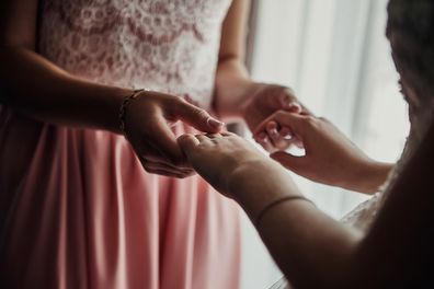 Bride on wedding day holding her mother's hands. Concept of relationship between moms and daughters