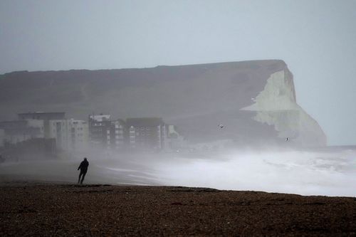 A person walks on Seaford Beach, as Storm Eunice hits Seaford and the south coast of England, Friday, February 18, 2022. 