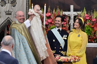 Chief Chaplain, Bishop Johan Dalman holds up Princess Ines after baptising her as Sweden's Prince Carl Philip, second from right, and Princess Sofia look on, in Drottningholm Palace Chapel, Stockholm, Friday, June 13, 2025. (Anders Wiklund/TT via AP)