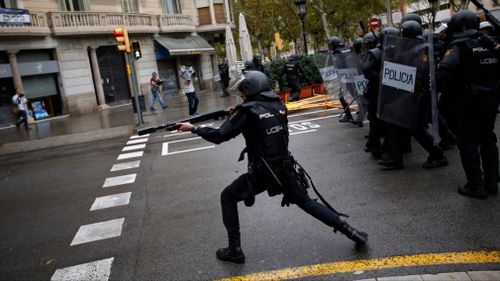 Spanish riot police shoots rubber bullet straight to people trying to reach a voting site at a school assigned to be a polling station by the Catalan government. (AP)