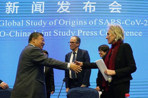 Marion Koopmans, right, and Peter Ben Embarek, center, of the World Health Organisation team say farewell to their Chinese counterpart Liang Wannian, left, after a WHO-China Joint Study Press Conference at the end of the WHO mission in Wuhan, China on Feb. 9, 2021. 