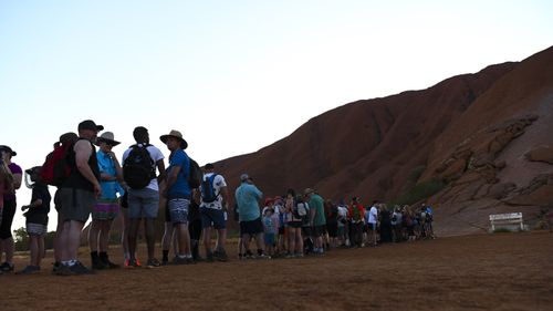 Tourists are seen lining up to climb Uluru, also known as Ayers Rock at Uluru-Kata Tjuta National Park in the Northern Territory.