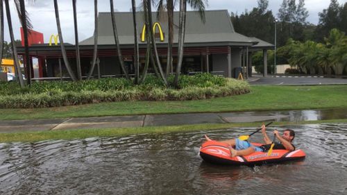 A man rowed down a flooded road in Tuggerah, on the Central Coast of NSW. (Aaron Paul via Facebook)