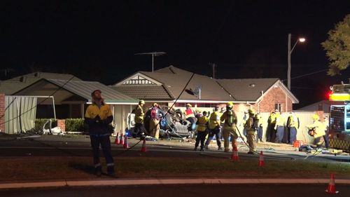 Emergency services work to free three teenagers trapped in the upturned wreckage of their Holden Rodeo at Emu Plains. (9News)