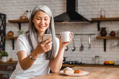 Older woman relaxing at home. Older woman eating breakfast.