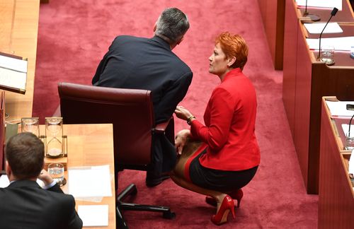 Mr Cormann chats with One Nation leader Pauline Hanson in the Senate chambers yesterday. Picture: AAP