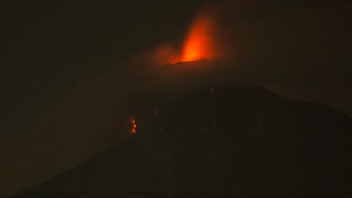 In this image taken with a long exposure, the Volcan de Fuego, or Volcano of Fire, spews hot molten lava from its crater. (AAP)