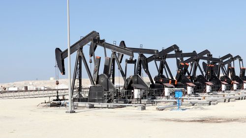 Martinetti neri della pompa dell'olio nel deserto del Bahrein.